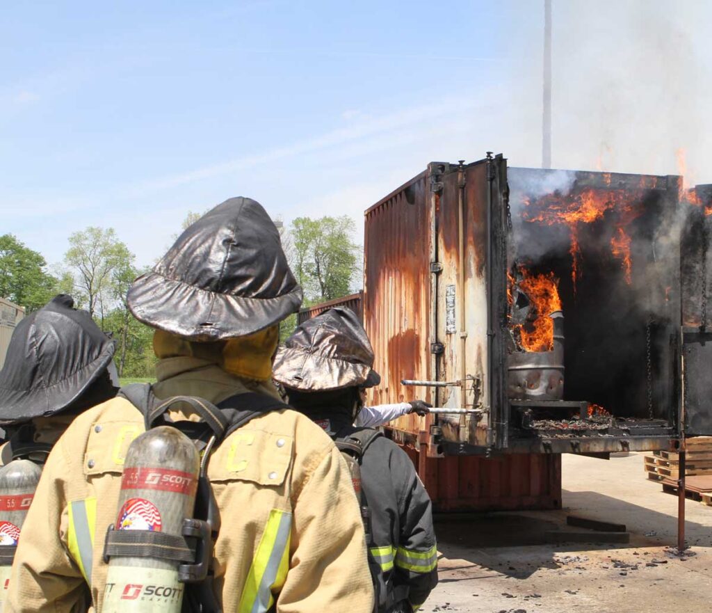 Firefighter students outside flashover container training FDIC 2017