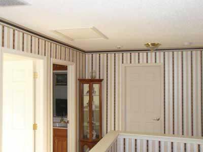 (4) At first glance, the main access into the attic would seem to be the scuttle hatch in the ceiling at the left. It is actually through the door to the right of the curio cabinet.