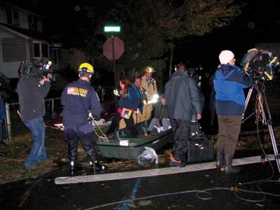 (2) VA-TF1 personnel aided New Jersey rescue personnel in rescuing stranded victims within a block of the Little Ferry command post, depositing them on dry ground. No personal flotation devices were required since the water was only knee-deep at this point. [Photos courtesy of the Federal Emergency Management Agency (FEMA).]