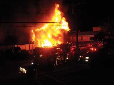 (2) Three minutes and 58 seconds later (after photo 1), it was clear that the fire had entered the first floor, as evidenced by the first-floor window on the Bravo side and the fully involved eaves.