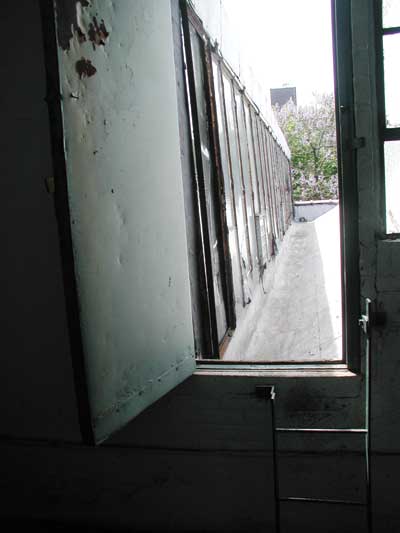 Interior access to the door off a vertical ladder reveals a narrow valley gutter of the saw-tooth roof.