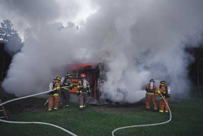 (1) Members of the Haughton (LA) Fire Department operate two 1¾-inch lines on a training fire using a school bus loaded with Class A fuels.