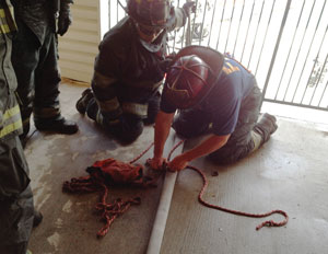 Firefighters learn the proper rope technique to perform a rope stretch of a handline, demonstrated by the senior firefighter.