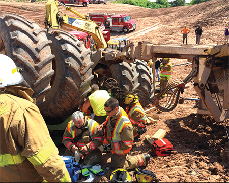 (3) De Pere firefighters prepare an IV for the trapped victim.