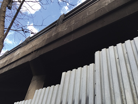 Corrugated steel blocked access to the fire. This photo shows the area where the fire occurred; it was a large area of rubbish underneath the highway, not the bulkhead itself this time. 