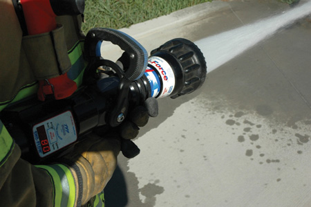 (1) The nozzle bail is fully open and flowing 140 gallons per minute (gpm) at 100 pounds per square inch (psi). <i></noscript>(Photos by author.) </i>(2) The nozzle bail is opened at around 50 percent and flowing 115 gpm at 100 psi. (3) The nozzle bail is opened at around 30 percent and is flowing 80 gpm at 100 psi.”></td>
</tr>
<tr>
<td align=