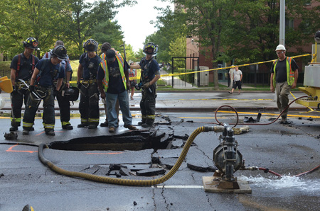 (3). A broken water main has left a water-filled sinkhole that public works personnel are pumping out. At night, flowing water would hide the hole. A firefighter could easily step into the hole if he was careless enough to enter the water without probing ahead with a tool as he walked. (Photo by Lloyd Mitchell.)