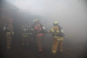 Firefighters moving through smoke