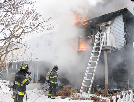 (2) A view of the rear of the building. You can see how the fire started on the first floor, exposed the outside of the building, and traveled to the soffits. This allowed fire to get into the attic space.