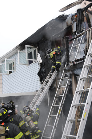 (7) The member was allowed room on the ladder to spin and come around to a feet-first descent. Members at the base of the ladder braced it for safety.