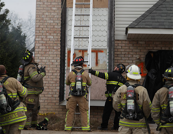 A firefighter holds a ladder on the training ground.