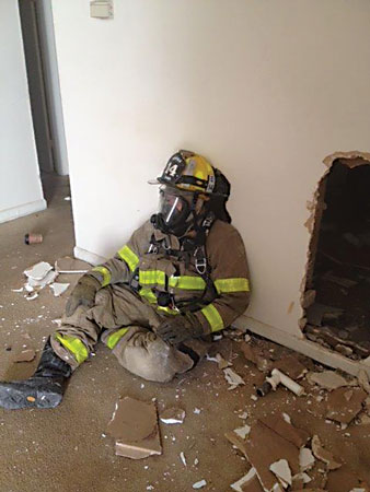 (<b>3, 4)</b> Here, the firefighter has breached the wall and begins to “swim” backward to make entry into an adjacent compartment. Keep in mind that you should create a hole big enough to get you through while limiting the space for heat and smoke to travel.