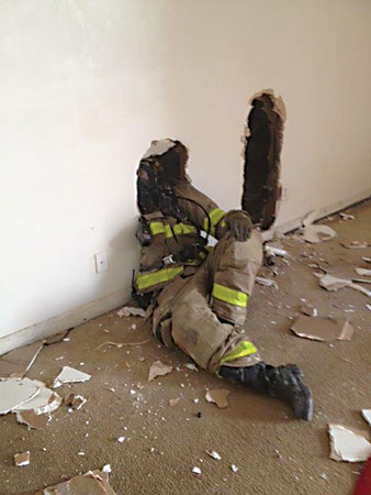 (<b>3, 4)</b> Here, the firefighter has breached the wall and begins to “swim” backward to make entry into an adjacent compartment. Keep in mind that you should create a hole big enough to get you through while limiting the space for heat and smoke to travel.