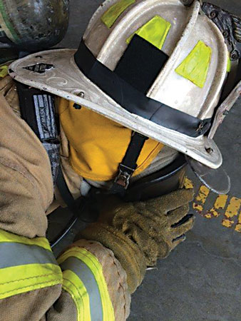 <b>(6, 7) </b>The mask sucks the firefighter’s face, and he immediately drops to the floor and places the mask as close to the ground as possible. He must crack the seal of the mask under his chin just enough to let some air in and then replace it as he exhales. Using the neck strap of the coat, he should tuck his face down to stay as covered as possible. He can perform this several times until he finds a place of refuge.