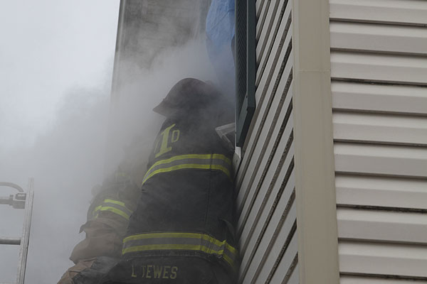 Firefighters at the window are enveloped in smoke on the training ground.