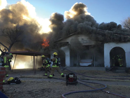 (5) Heavy smoke shows from around the soffits and the roof area. It is almost impossible to know that the peak was placed over an existing flat roof.<i> (Photos 5-8 by Bo Phillips.) </i>