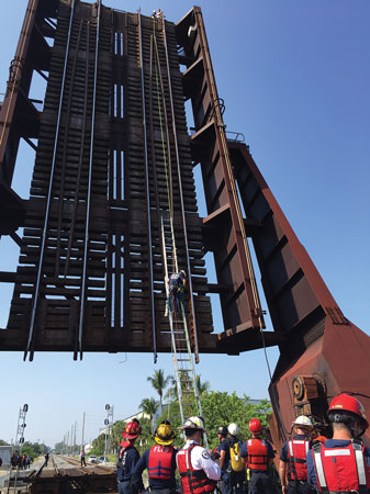 (5) Fort Lauderdale firefighters ascend a rope on a bridge to secure a person who is stuck at the top. Rope rescues can occur anywhere. Use creativity in preplanning for incidents. 