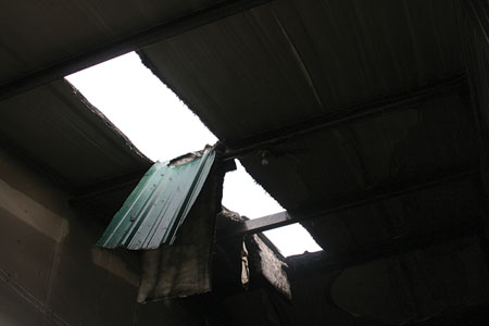 (4) Cutting the roof can be extremely dangerous since the steel roof supports can be four to six feet on center. A firefighter cutting such a roof can fall into a burning storage unit. [Photo courtesy of the Spokane (WA) Fire Department.]