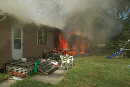 (4) A view of side C showing fire in an enclosed porch. Smoke from the eaves indicate extension to the attic <i></noscript>(Photos 4-5 by Billy Adkins.) </i>“></td>
</tr>
<tr>
<td align=