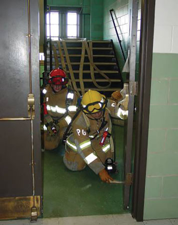 (3) Firefighters train in how to set up a hoseline from a stairway standpipe. Coordinating standpipe design with fire service nozzle types, hose sizes, and operating procedures is critical.