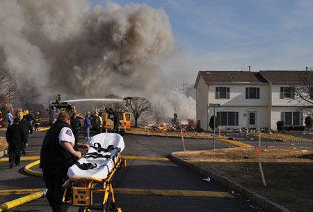 (2) The house exploded. This stretcher was to be Knapp’s ride to the trauma/burn center. Note the gas company trucks just beyond the stretcher. 