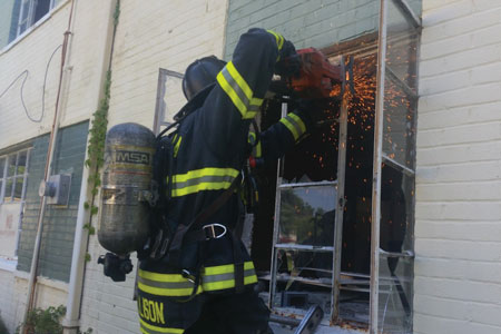 (5) A firefighter uses a rotary saw to cut the top portion of a steel casement window. Rotary saws are more effective than hand tools on casement windows.