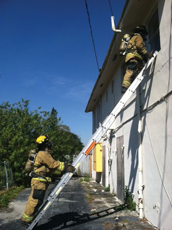 (5) The search position FF has vented the window, cleared the frame/sash, and is about to make entry. The window position FF begins to ascend the ladder, ideally with a TIC so that the member can monitor conditions and search progress.