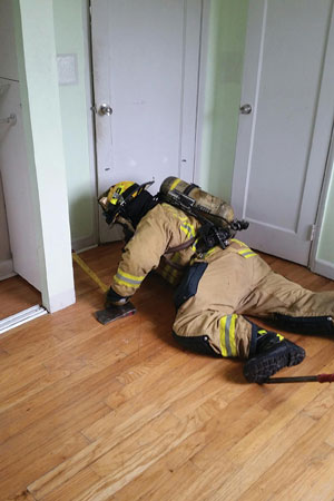 (9) Although the bedroom door was already closed, the searcher briefly opens it to check for victims and assess fire conditions, then closes it.