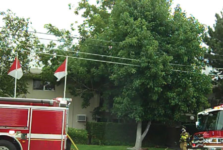 (6) This garden-style apartment fire was supervised by the rescue group supervisor and fire attack group supervisor (seen at the bottom right), calling for more line from the engineer. He promptly returned to the rear to maintain contact with his crews. Both supervisors were company officers since the second battalion chief to the fire was delayed. 