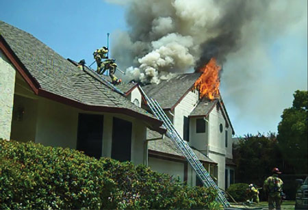 (7) The Division A supervisor is seen on the right. He is moving around the structure, coordinating vertical ventilation with his crews inside, orbiting and entering the structure when necessary to account for and communicate with crews face-to-face. 