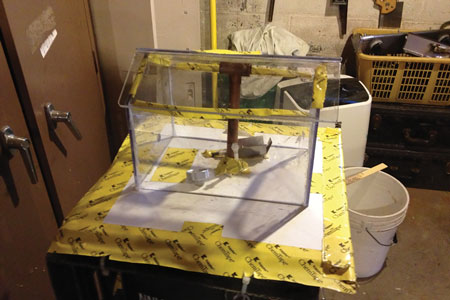 (2) A plexiglass house model with the roof not secured. The roof rises a few inches when the gas ignites.