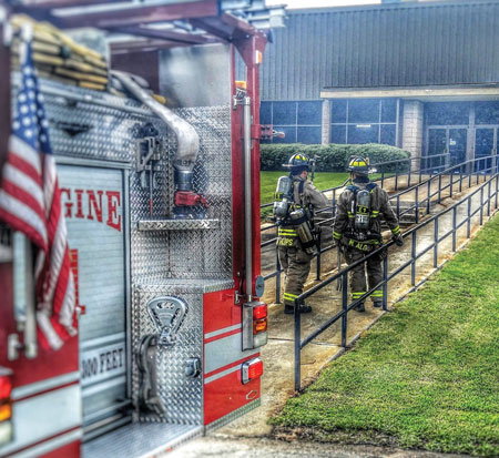 (3) Firefighters approach a nothing-showing incident carrying the appropriate tools and equipment to be prepared if they discover fire during their investigation. (Photo by Keith Conner.)