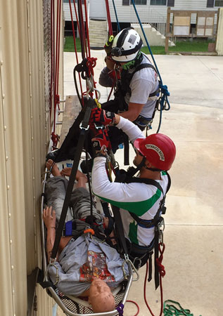 (18) Rescuers have backboarded the worker and moved him into a Stokes basket.