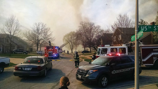 (4) Fire raged on both sides of the street as master streams and hoselines were moved from house to house. <i>(Photo by Spencer Carey, The Campus Ledger, Johnson County Community College.)</i>