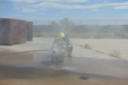 A piercing nozzle spray pattern demonstration using a roof and attic space prop and (5) an end view of the spray pattern.