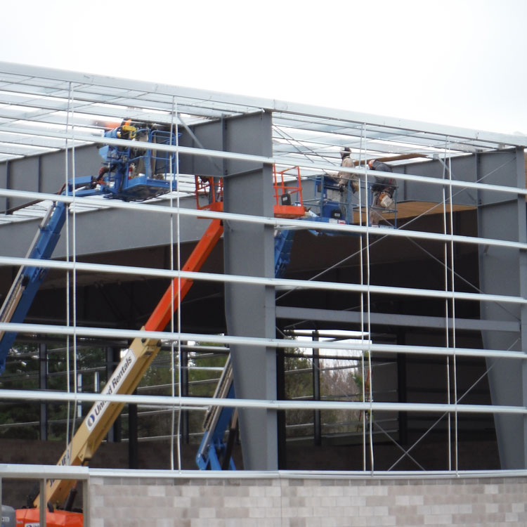 Steel erectors working from telescoping boom aerial work platforms.