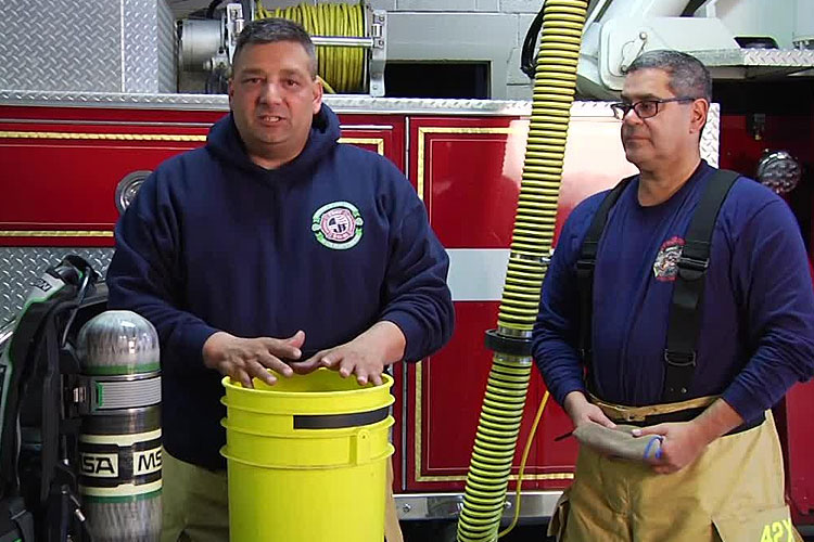 Firefighters decontaminate a SCBA face piece and straps