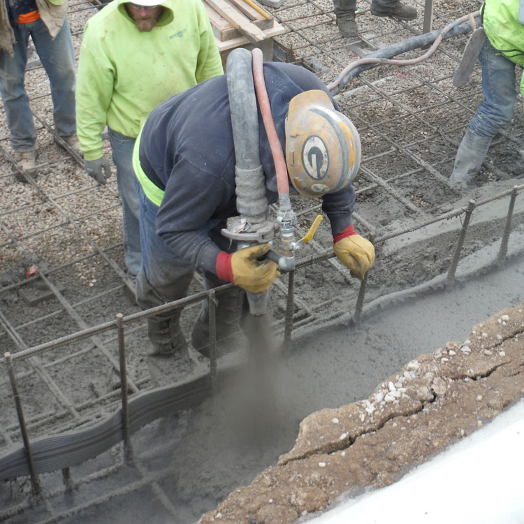 Nozzleman applies shotcrete to construction of municipal swimming pool