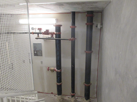 (8) Three risers at the ninth floor landing. (Left) the low-zone riser terminates, (center) the express drain riser, (right) the high-zone riser is devoid of outlets. The outlets for the high zone begin at the 10th floor. 