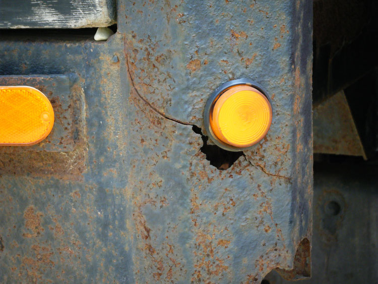 Part of the steel frame of a truck that has been severely corroded