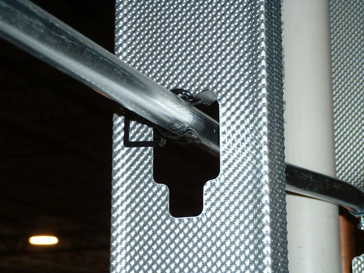 Galvanized steel electrical conduit in a wall framed with galvanized steel studs