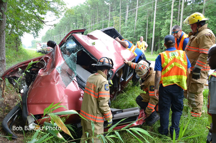 Firefighters perform extrication at a single-vehicle accident