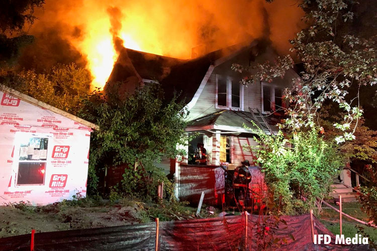 Firefighters confront a fire in an abandoned home