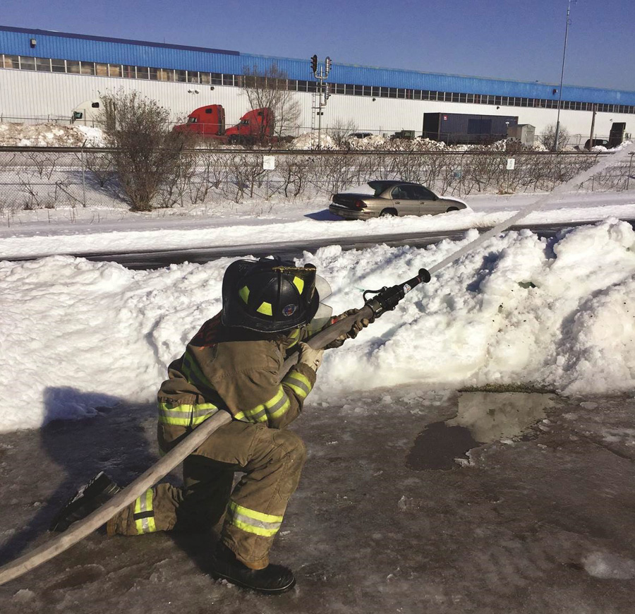 A single firefighter employs the lock-off or Comella method to safely manage the nozzle reaction of a 7⁄8-inch smooth bore nozzle.