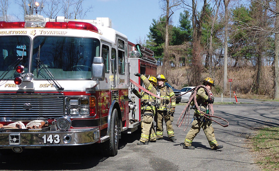 He steps about 10 feet away from the apparatus and waits for the backup firefighter to load his hose bundle 