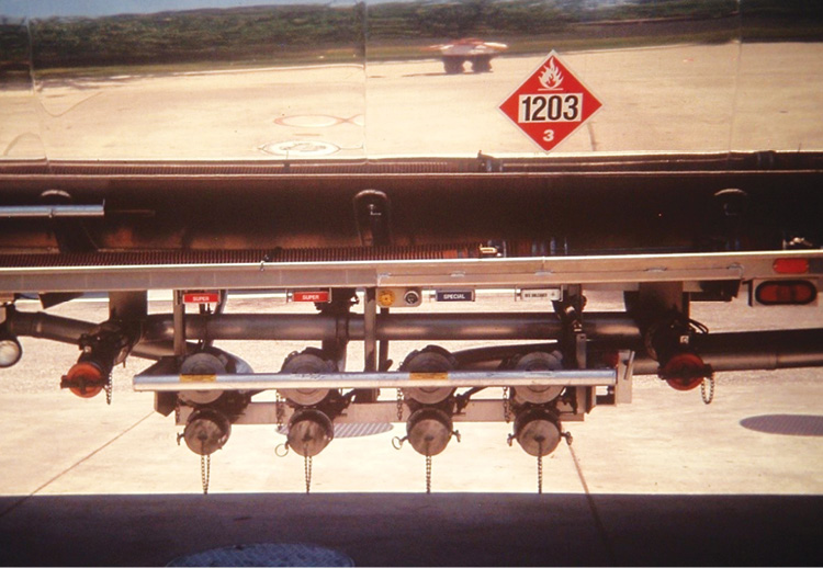 These four external ports and valves have separate intake (top) and discharge ports (bottom). The capped pipes on each side are vapor recovery lines.