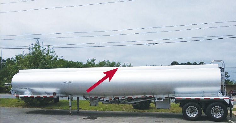  A typical MC-406 tanker trailer. Along the top is the eight-inch overturn protection rail (arrow) through which runs the vapor recovery system and the access ladder at right. 