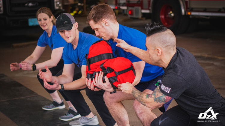 O2X trainer working with firefighters in a drill