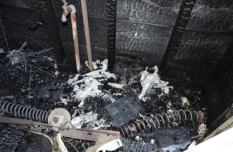 The point of origin before the area was cleared. The white material is the remains of the ladder, which is mixed in with the white plastic from the lawn chairs (Photos by author.)
