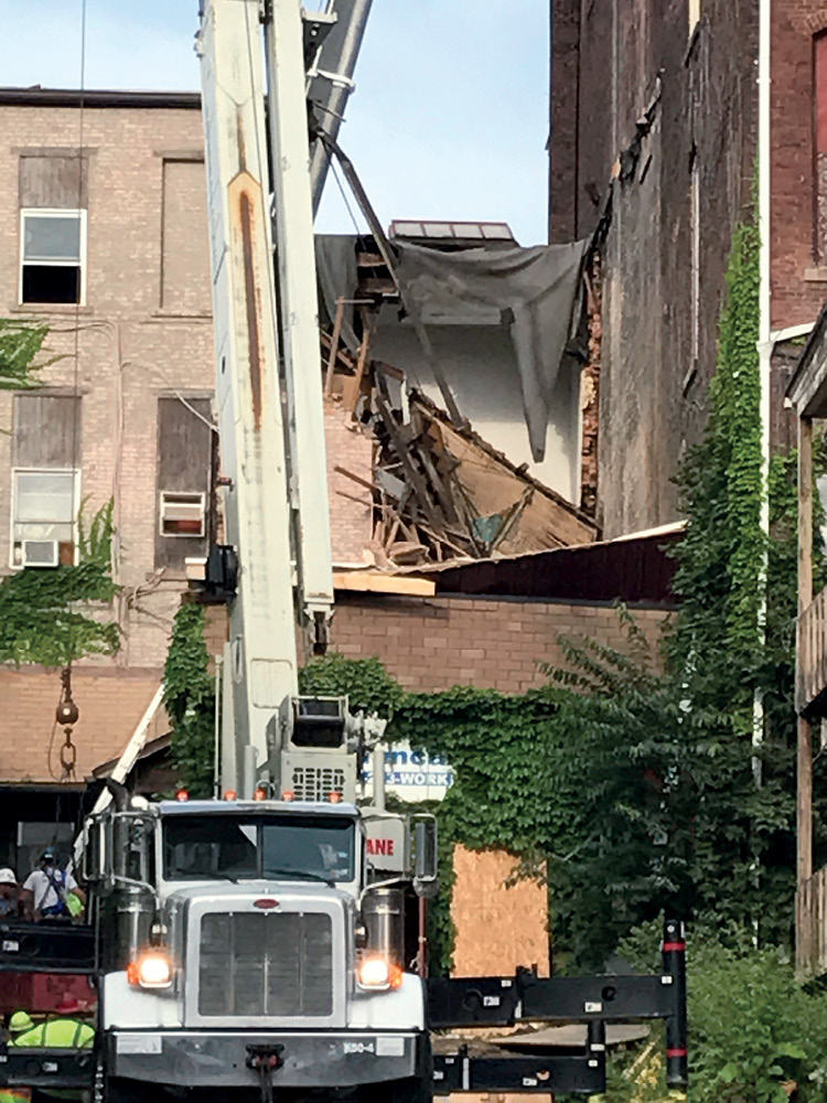 The abutting B side exposure and the collapsed roof of the two-story C side addition, the scene during the rescue after the secondary collapse. (Photo by John Soderberg.)